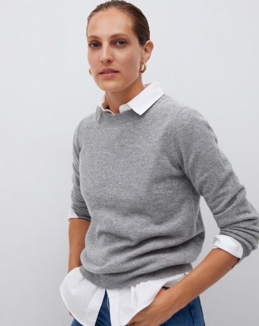 side view of model wearing gray sweater over white shirt
