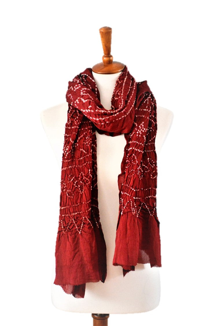 red scarf draped on form in front of white wall